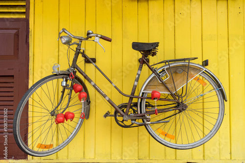 retro bicycle hang on yellow wall