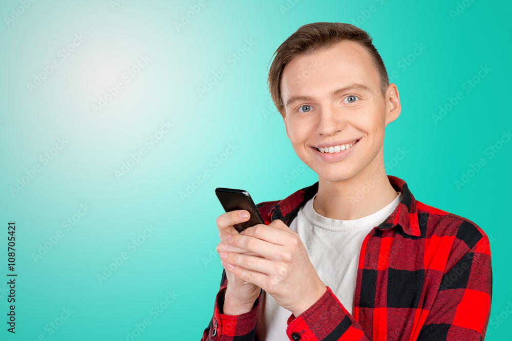 Young man typing text message on his cellphone Young man typing text message on his cellphone