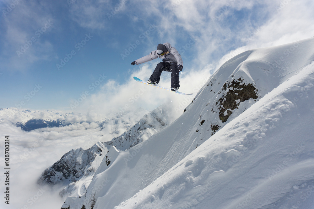 Snowboard rider jumping on mountains. Extreme snowboard freeride sport.