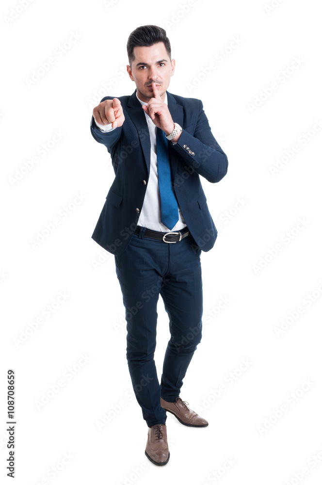 Businessman making keep a secret gesture standing on white backg Businessman making keep a secret gesture standing on white backg