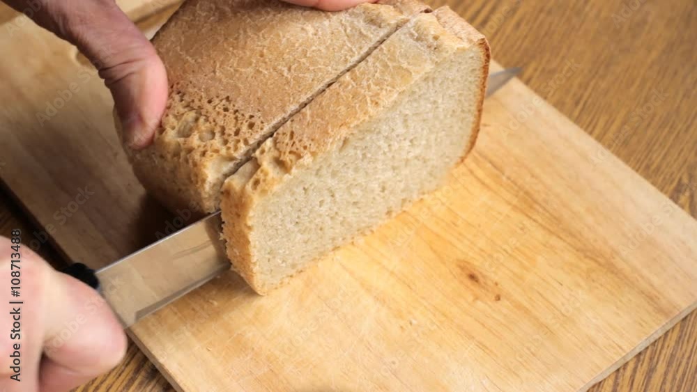 Hands slice loaves of bread Hands slice loaves of bread