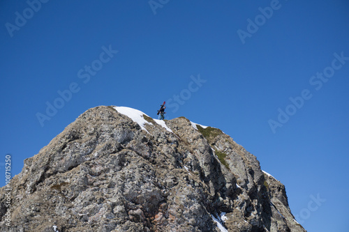 Man with snowboard on top of a mountain, extreme moutaineering.