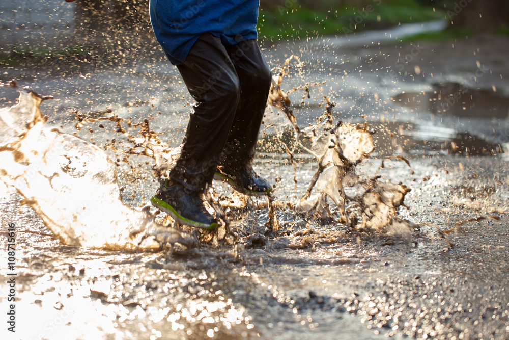 Little boy splashing in a mud puddle, jumping into a puddle
Little boy splashing in a mud puddle, jumping into a puddle