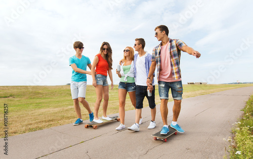 happy teenage friends with longboards outdoors