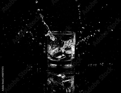 Isolated shot of whiskey with splash on black background