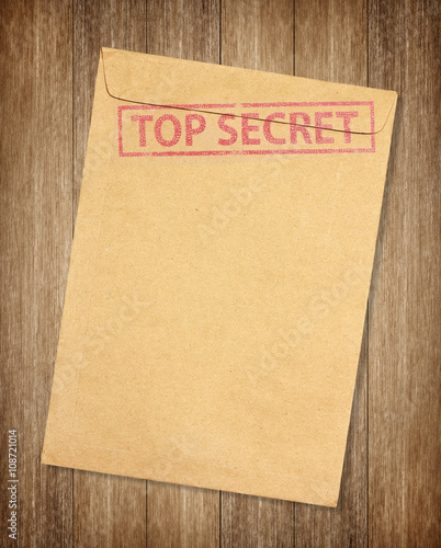 Brown envelope with top secret stamp isolated on on wood backgro