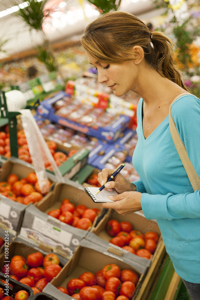 Obraz premium femme qui fait des courses au supermarché