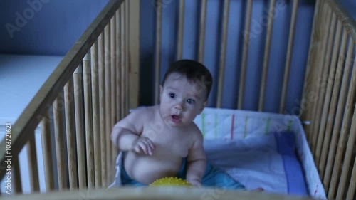 Cute baby playing in a crib
 photo