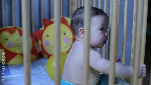 Cute baby playing in a crib
 photo