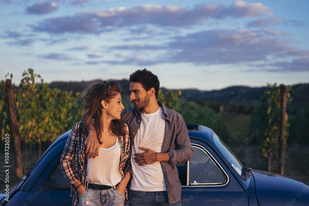 Young couple doing a road trip in Tuscany countryside in a vintage car Young couple doing a road trip in Tuscany countryside in a vintage car