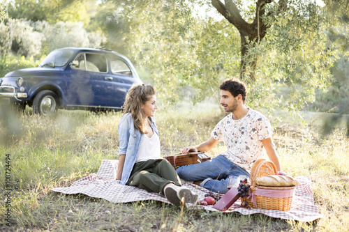 Young couple in love doing a picnic outdoors in Tuscany wine country
