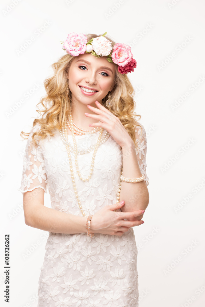 Portrait of a cheerful girl with wreath of flowers. Isolated on white background with copyspace for your text. Touching head. Youth, happiness concept.