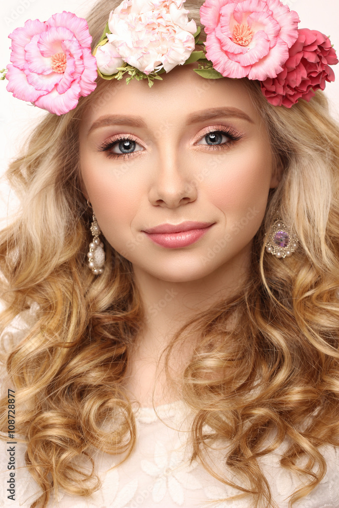 Close-up beauty portrait. Beautiful blonde girl with wreath of flowers. Looking at camera. Isolated on white background