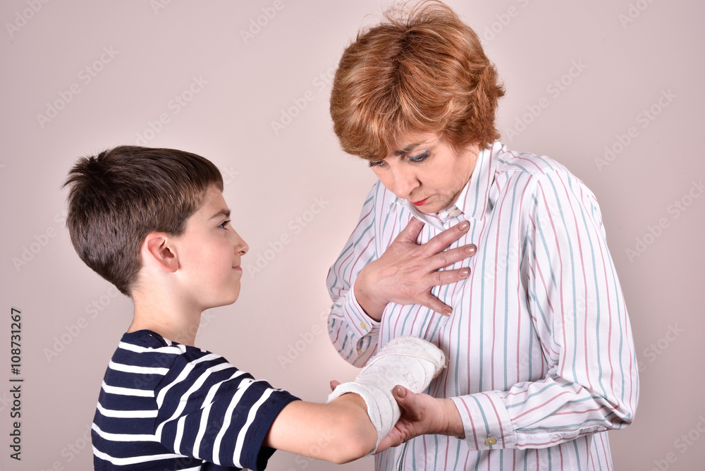 Son showing his broken arm with plaster to his mother Son showing his broken arm with plaster to his mother
