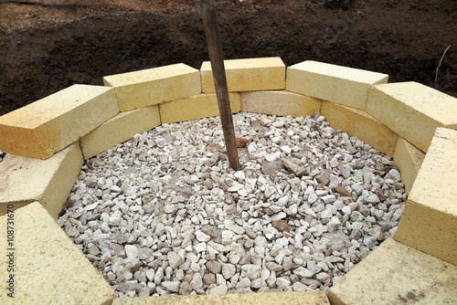 Step by step making of a fire pit using yellow aluminous bricks photo