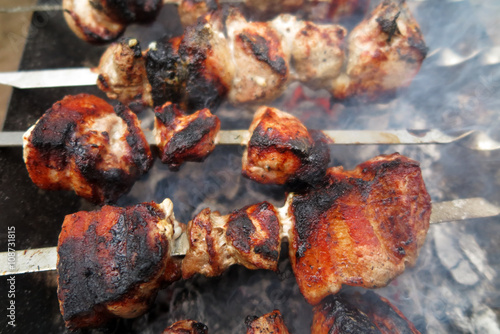 Pork shashlyk (shish kebab) roasting on skewers in the garden