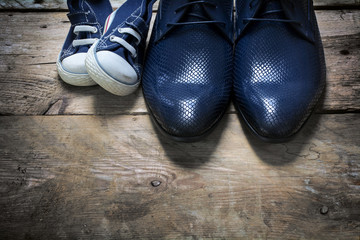 father's shoes and kids sneakers side by side on rustic wood, father's day