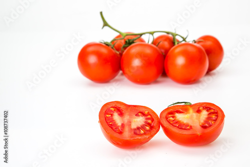 Two chili pepper and cherry tomatoes on stem top view isolated on white background