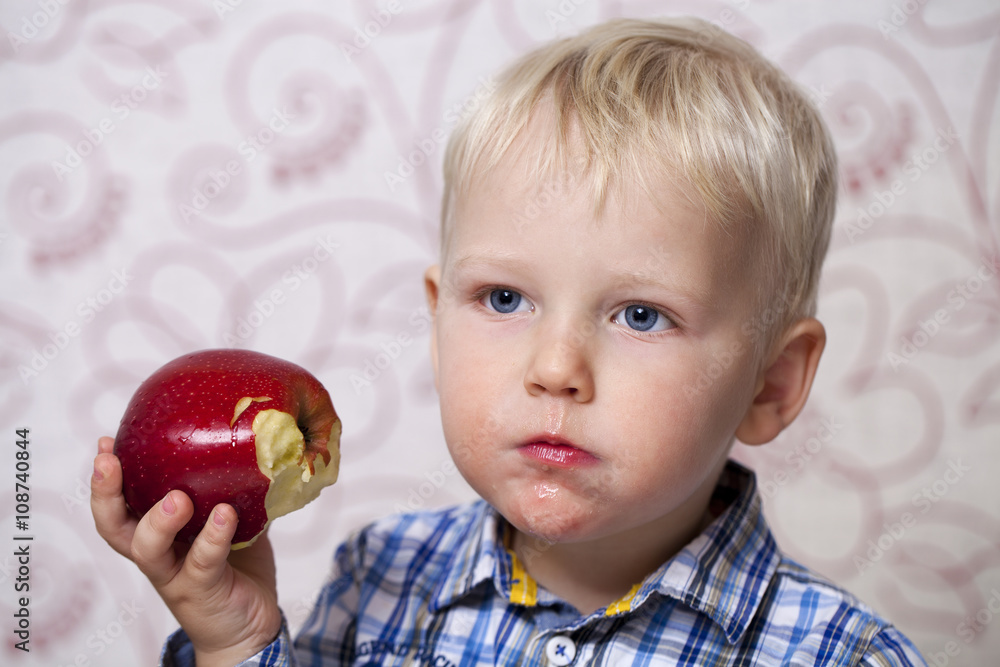 Cute little boy eating red apple Cute little boy eating red apple