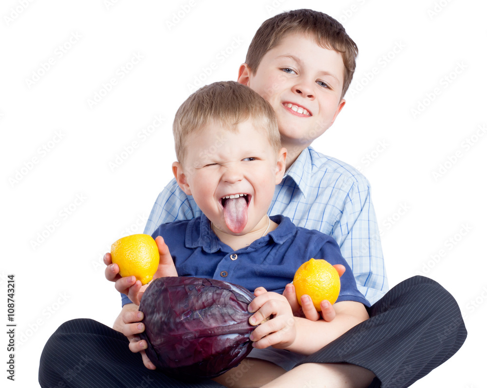 Two brothers eating vegetable and lemons Two brothers eating vegetable and lemons