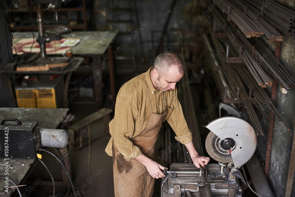 The wizard installs the part for cutting parts on a circular saw in the workshop The wizard installs the part for cutting parts on a circular saw in the workshop