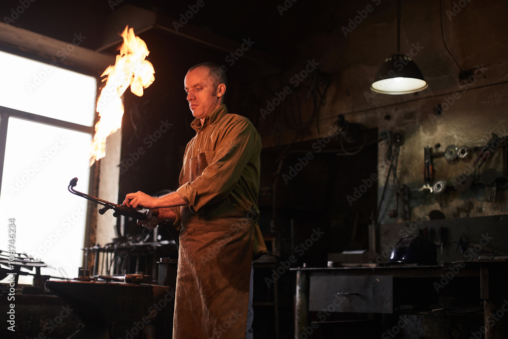 The blacksmith heats the gas burner before working in the workshop