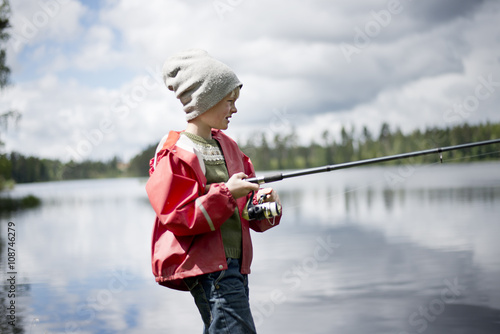 Boy fishing in river photo