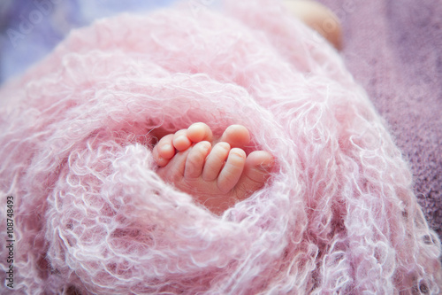 the heel of the newborn in a pink blanket