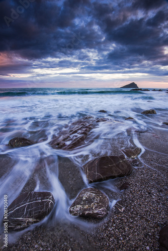 Red rocks on beach at sunset photo