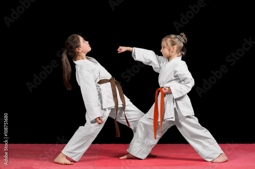 Two girls in kimono are training paired exercises karate © fakezzz