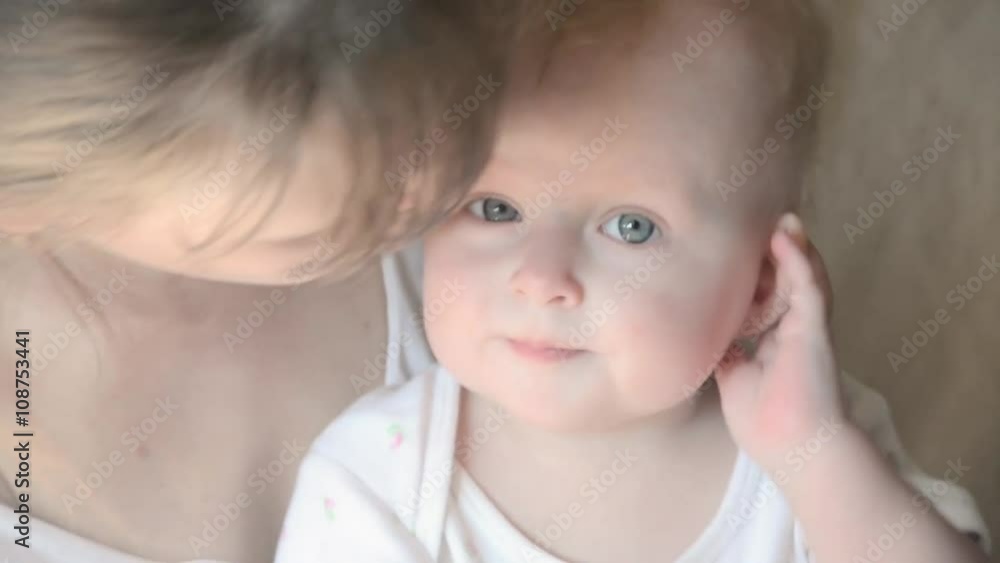 Closeup portrait of beautiful gentle mother playing with cute little baby on the bed loving young family Closeup portrait of beautiful gentle mother playing with cute little baby on the bed loving young family