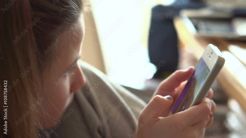 Child sitting and playing video game on cell phone/tablet.
Child sitting and playing video game on cell phone/tablet.