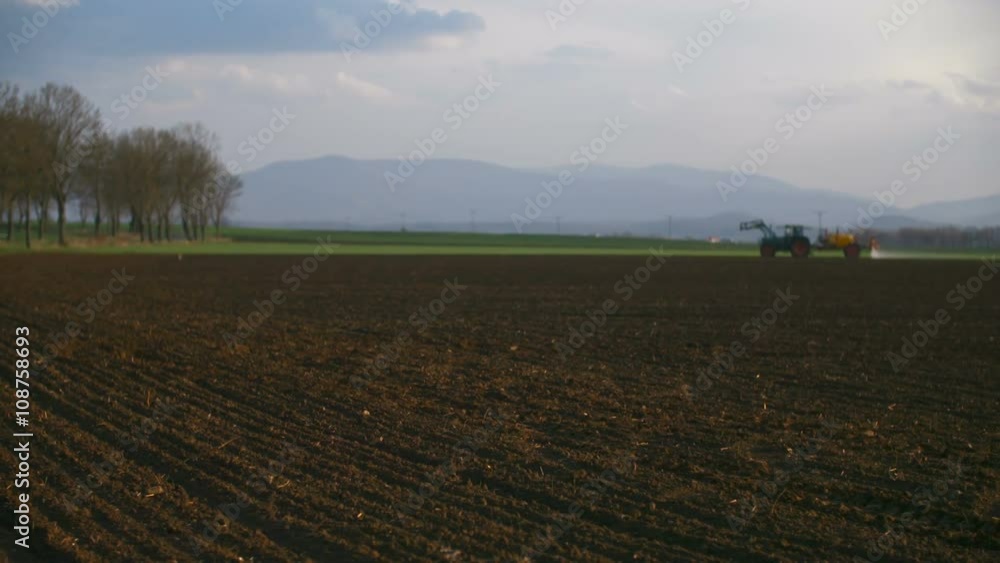 Tractor working in the field at sunset Tractor working in the field at sunset