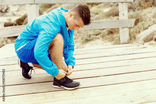 Runner laces his shoes and prepares to jogging