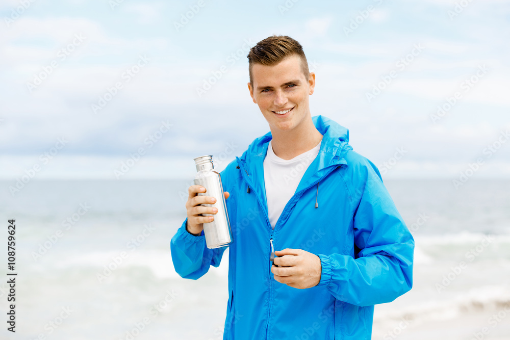 Confident young man holding bottle with water Confident young man holding bottle with water