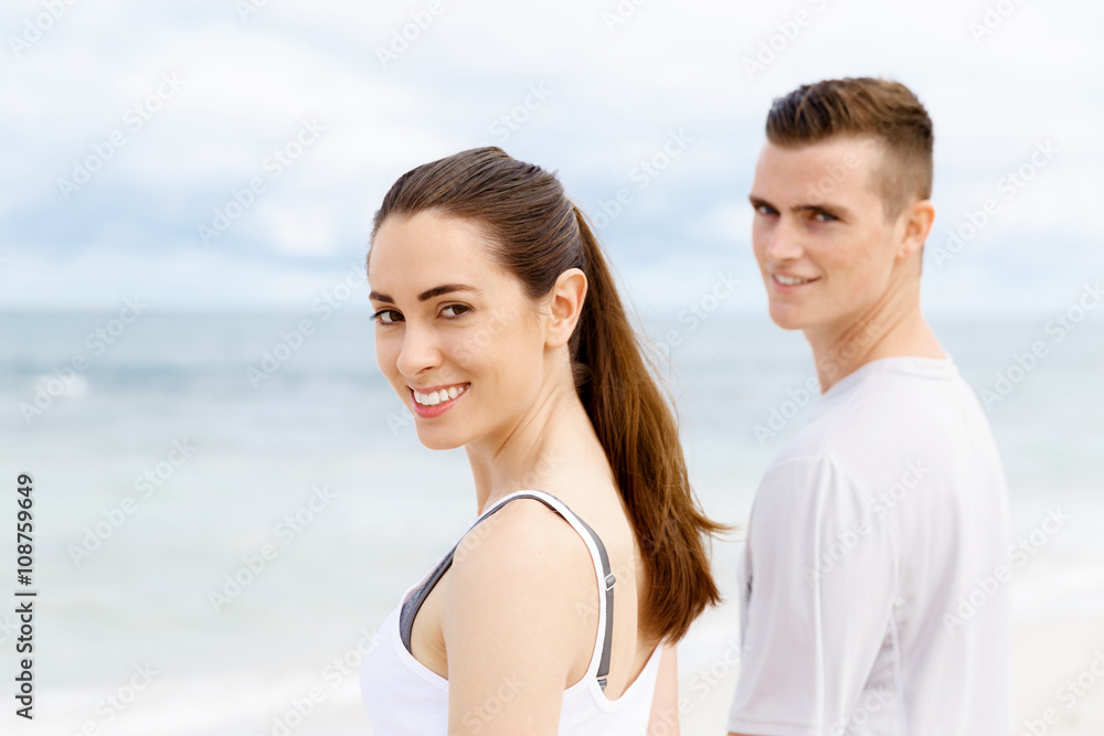 Young couple looking thoughtful while standing next to each other on beach Young couple looking thoughtful while standing next to each other on beach