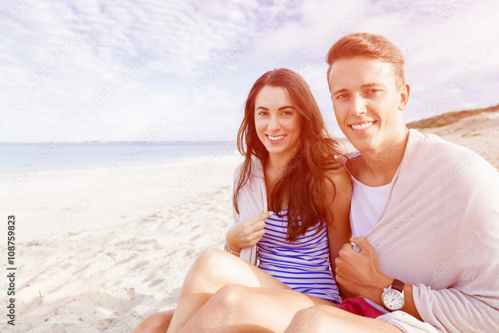 Romantic young couple sitting on the beach Romantic young couple sitting on the beach