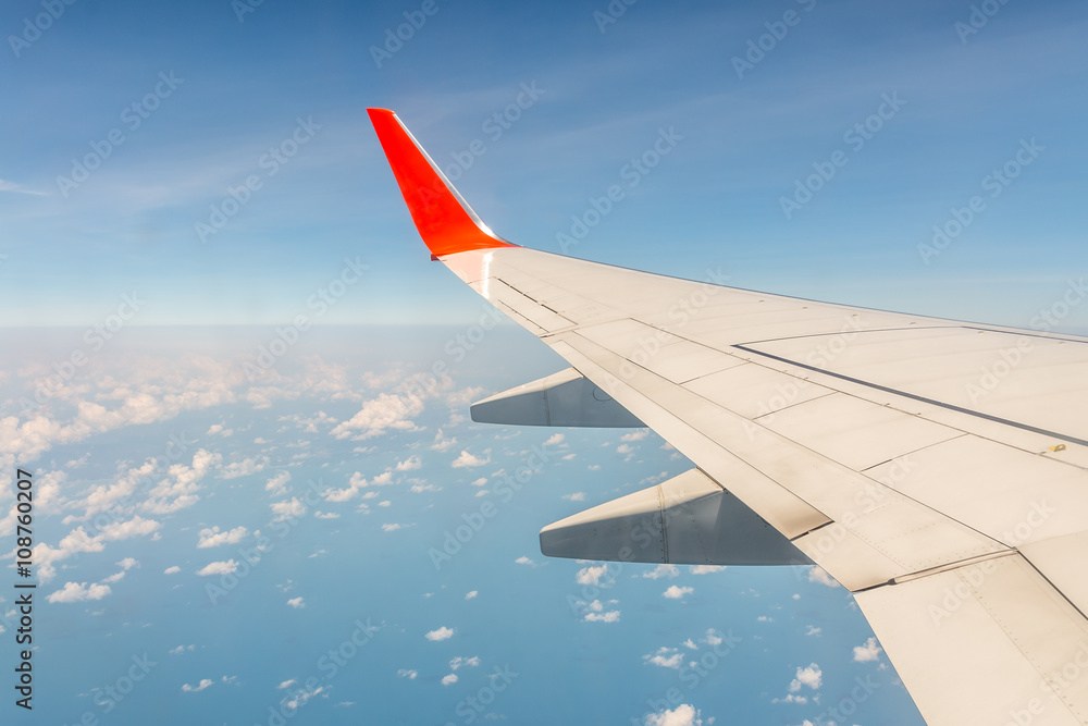 Wing of airplane from window with sea view on ground .