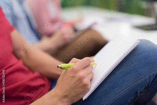 male student taking notes in classroom