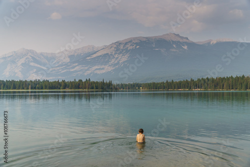 Fototapeta Naklejka Na Ścianę i Meble -  Child in Cold Glacier Water in Lake in Jasper National Park