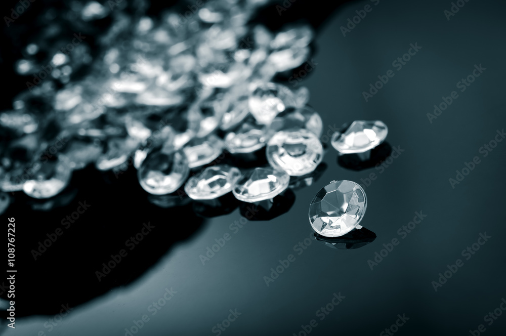 Black and white image of diamonds scattered on a shiny surface Black and white image of diamonds scattered on a shiny surface