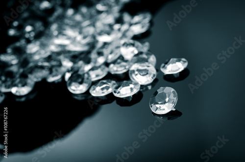 Black and white image of diamonds scattered on a shiny surface