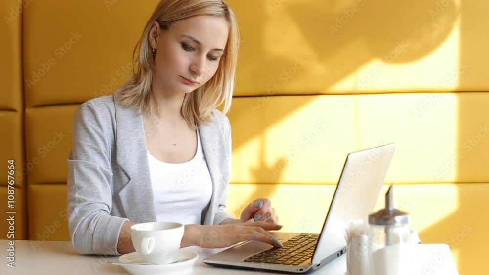 Young woman working on laptop in cafe