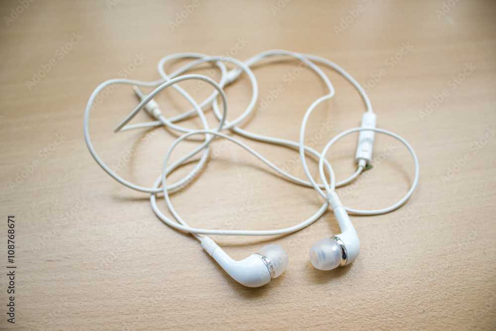 white earphone on wood table white earphone on wood table