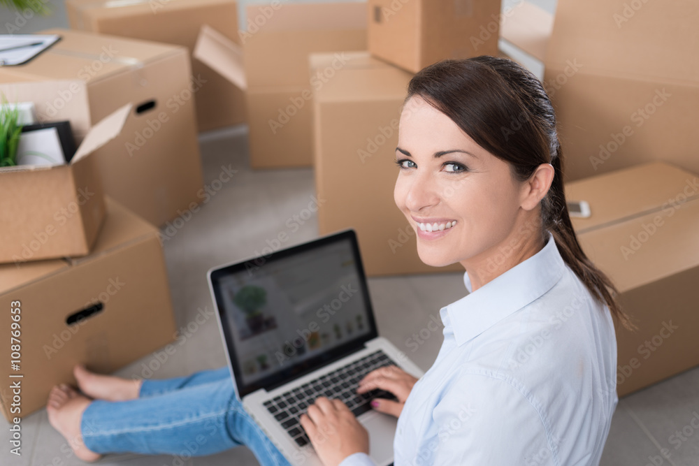 Beautiful woman sitting on the floor with a laptop Beautiful woman sitting on the floor with a laptop
