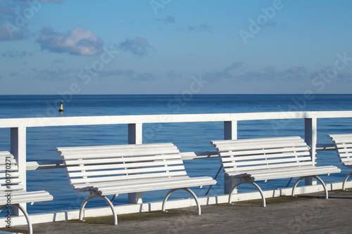 White comfort benches on sea walking pier