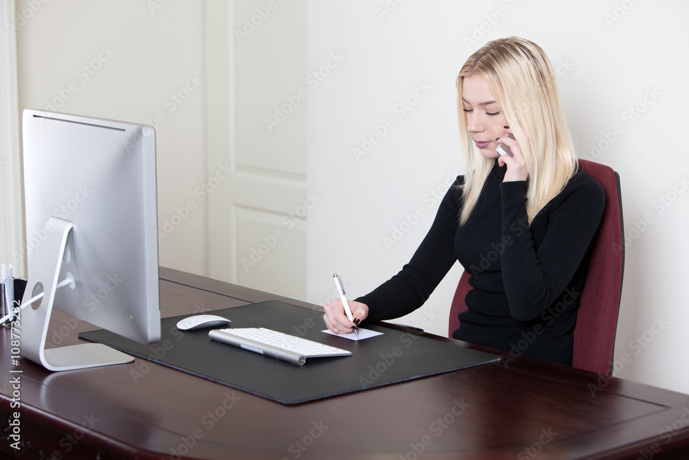 woman having a call and writes on a paper in office woman having a call and writes on a paper in office