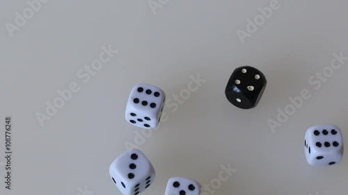 Playing dice, throw on the surface of white color. Dice of white and black. Visible to the palm of a man who throws the dice. Video shot close up on a Canon 70D. photo