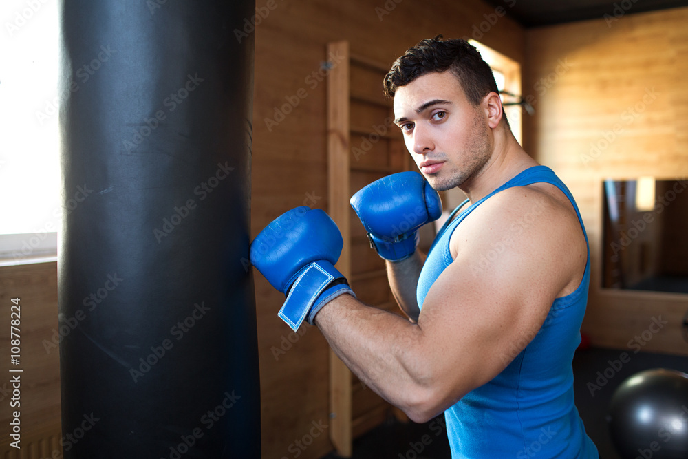 Young man boxing workout.boxer man during boxing hiting heavy bag at training fitness gym