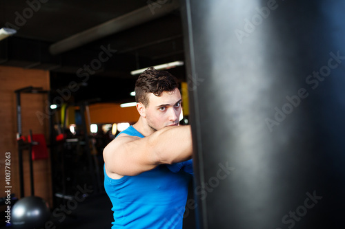 Young man boxing workout.boxer man during boxing hiting heavy bag at training fitness gym
